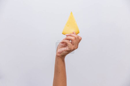 Téléchargez les photos : Gros plan de la main tenant un morceau de fromage provolone. - en image libre de droit