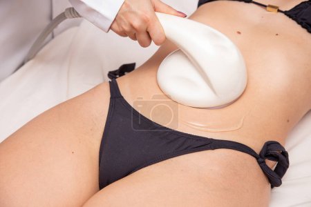 Téléchargez les photos : Gros plan d'une jeune femme faisant une échographie sur son ventre. Concept de spa - en image libre de droit