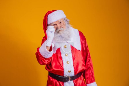 Photo for Santa Claus looking at the camera. Christmas is coming. Merry Christmas. Santa is watching. Holding his glasses. - Royalty Free Image