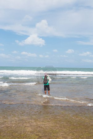Téléchargez les photos : Homme pêche avec une canne dans la mer - en image libre de droit