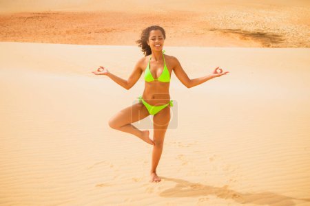 Photo for Afro woman meditating in the desert - Royalty Free Image