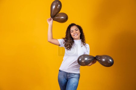 Photo for Afro woman with black balloons celebrating birthday offers. Black Friday sales - Royalty Free Image