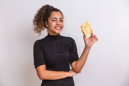 Photo for Young woman with a slice of cheese in her hand. woman eating parmesan cheese - Royalty Free Image