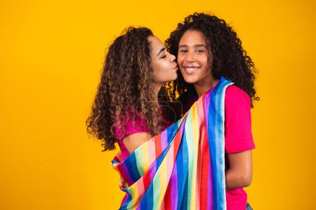 Foto de Pareja lesbiana mujer con gay orgullo bandera en amarillo fondo - Imagen libre de derechos