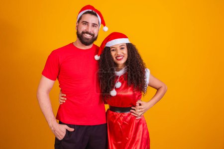 Photo for Young valentine couple dressed for Christmas night on yellow background with space for text. - Royalty Free Image