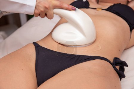Téléchargez les photos : Gros plan d'une jeune femme faisant une échographie sur son ventre. Concept de spa - en image libre de droit