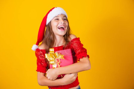 Foto de Emocionada niña caucásica con la boca abierta sosteniendo un regalo de Navidad. - Imagen libre de derechos