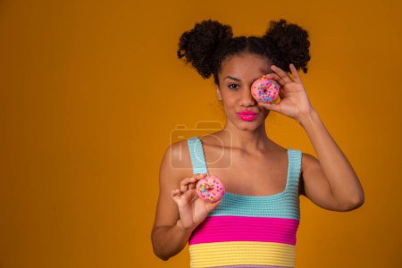 Photo for Young pretty afro woman with a donut - Royalty Free Image
