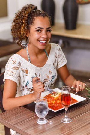 Photo for Woman eating a delicious dish of meat and noodles parmigiana. - Royalty Free Image