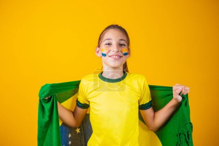 Photo for Football supporter, Brazil team. Beautiful little girl cheering for her team on yellow background - Royalty Free Image