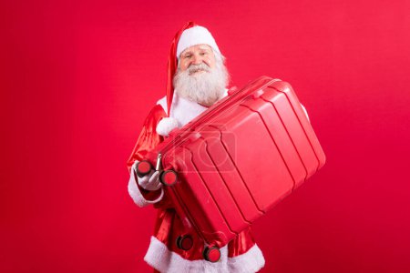 Téléchargez les photos : Le Père Noël avec sa valise. Concept de voyage du Nouvel An. Père Noël à l'aéroport
. - en image libre de droit