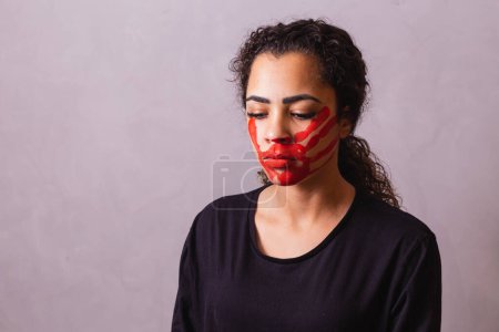 Téléchargez les photos : Femme afro avec une empreinte de main sur la bouche en faveur de la sensibilisation au féminicide. Violence domestique - en image libre de droit