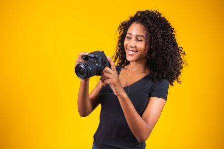 Téléchargez les photos : Jeune femme prenant des photos sur SLR - en image libre de droit
