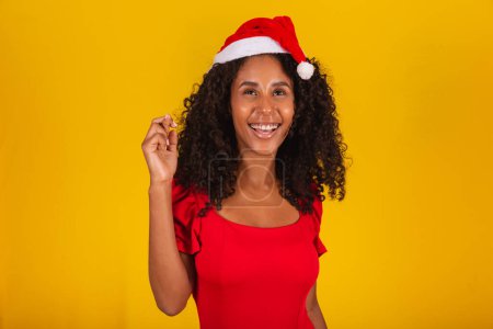 Téléchargez les photos : Jeune femme en tenue de Noël et santa claus chapeau avec les doigts croisés souhaitant bonne chance - en image libre de droit