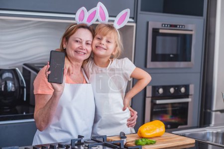 Foto de Niña con su madre cocinando para la Pascua - Imagen libre de derechos