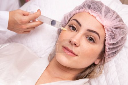 Téléchargez les photos : Gros plan de la femme appliquant de l'ozone sur son visage pour le traitement cosmétique. - en image libre de droit