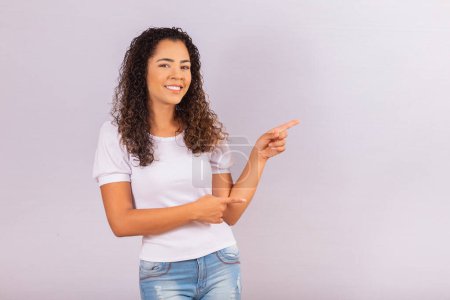 Photo for Image of cheerful young afro woman pointing on free space for text. - Royalty Free Image