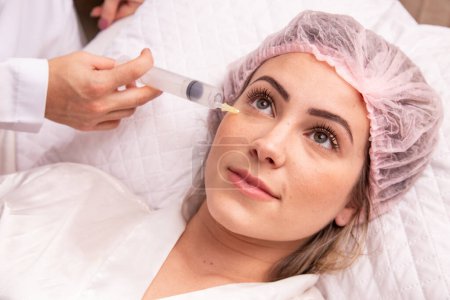 Photo for Closeup of woman applying ozone to her face for cosmetic treatment. - Royalty Free Image