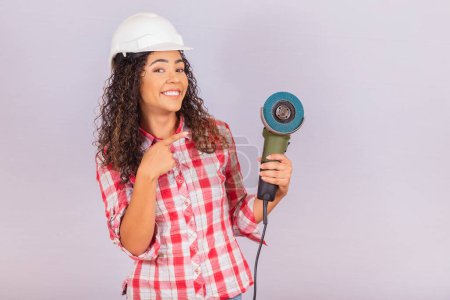 Photo for Afro woman holding an electric sander. building material concept - Royalty Free Image
