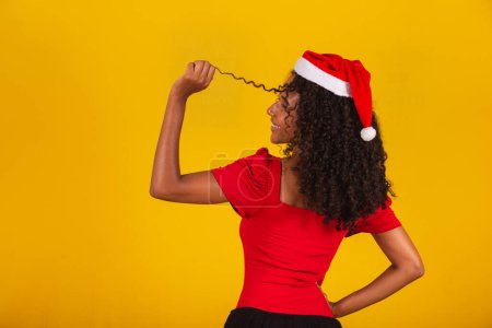 Photo for Closeup of smiling afro woman with santa hat smiling at camera - Royalty Free Image