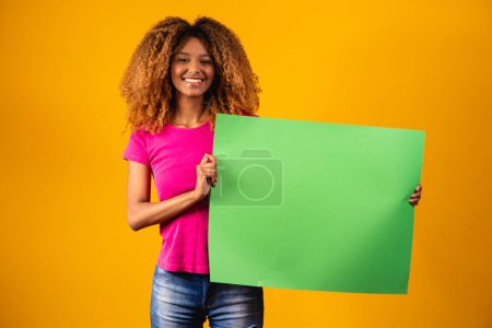 Téléchargez les photos : Afro femme tenant une affiche chromatique verte. - en image libre de droit