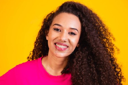 Photo for Beauty portrait of african american woman with afro hairstyle and glamour makeup. Brazilian woman. Mixed race. Curly hair. Hair style. Yellow background - Royalty Free Image