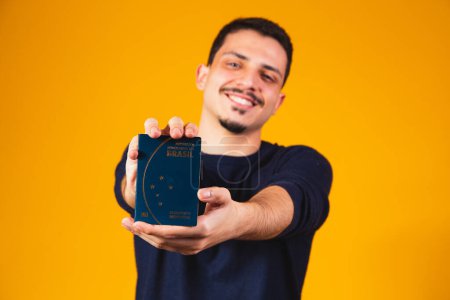 Foto de Retrato de un chico con un pasaporte brasileño en sus manos. Concepto de viaje y migración - Imagen libre de derechos