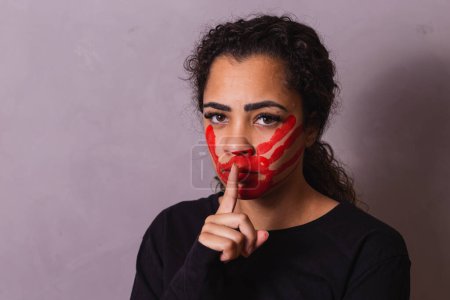 Photo for Woman with finger on mouth making sign of silence. Domestic violence - Royalty Free Image
