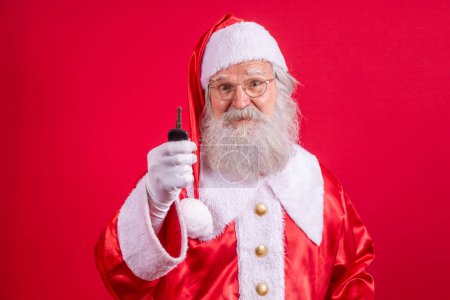 Téléchargez les photos : Père Noël tenant les clés d'une voiture sur fond rouge - en image libre de droit