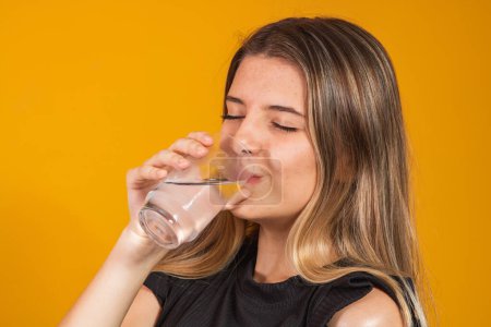 Téléchargez les photos : Jeune fille blonde se hydrater l'eau potable - en image libre de droit