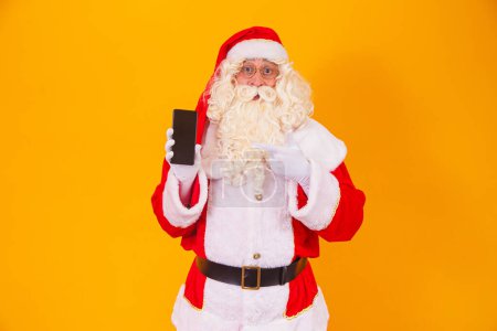 Téléchargez les photos : Père Noël tenant un smartphone dans les mains - en image libre de droit