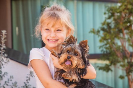 Photo for Close up little girl  holding a pet. Girl holding a dog - Royalty Free Image