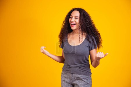 Photo for Portrait of happy beautiful young afro woman with perfect smile raised her hands up and celebrate achievement goal. - Royalty Free Image