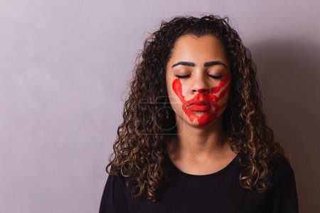 Photo for Afro woman with handprint on her mouth in favor of awareness of feminicide. Domestic violence - Royalty Free Image