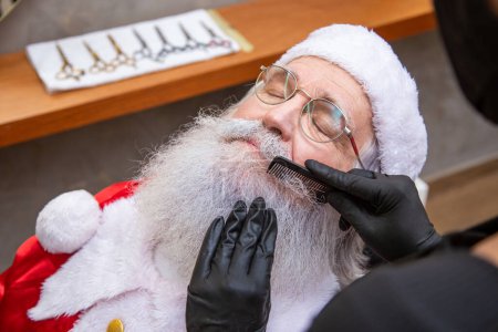 Photo for Santa Claus shaving in barbershop. Getting ready for Christmas. Beautifying for the holidays. Bearded. Cuting. - Royalty Free Image