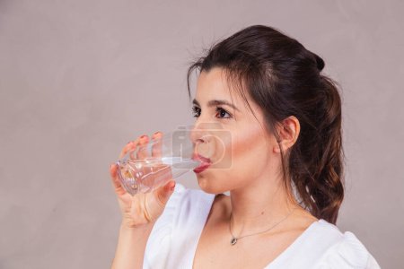 Photo for Beautiful caucasian woman drinking a glass of water. - Royalty Free Image