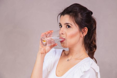 Téléchargez les photos : Belle femme caucasienne boire un verre d'eau. - en image libre de droit