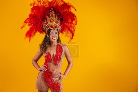 Téléchargez les photos : Femme afro brésilienne posant en costume de samba sur fond jaune avec de l'espace libre. costume brésilien habillé Samba. - en image libre de droit