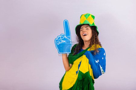 Foto de Afro mujer mirando cámara sosteniendo guante de fútbol en traje brasileño. - Imagen libre de derechos