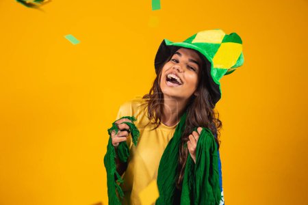 Photo for Young woman supporter from Brazil with flag and dressed for the game. - Royalty Free Image