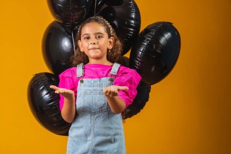Photo for Smiling little girl with black balloons on black friday. low price festival - Royalty Free Image