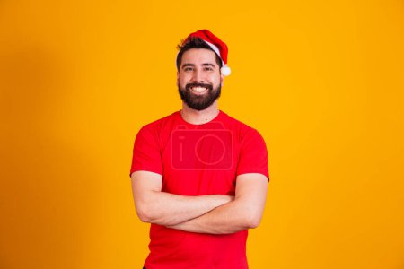 Photo for Portrait of young handsome boy in Santa hat looking at camel smiling with arms crossed. - Royalty Free Image