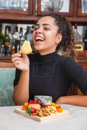 Foto de Mujer joven comiendo queso. mujer comiendo bocadillos de queso - Imagen libre de derechos