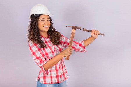 Photo for Contractor woman drilling the wall with hammer. - Royalty Free Image