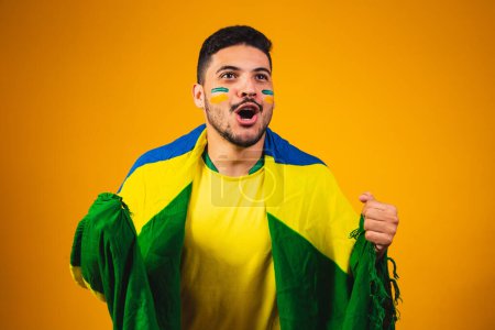 Photo for Brazilian fan cheering in the crowd on yellow background. - Royalty Free Image