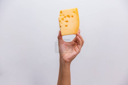 Téléchargez les photos : Gros plan de la main tenant un morceau de fromage élémentaire. - en image libre de droit
