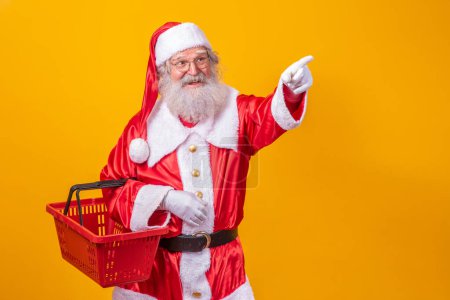 Foto de Santa Claus sosteniendo una cesta vacía mirando a la cámara sonriendo. - Imagen libre de derechos
