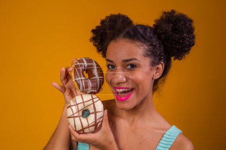 Photo for Young afro woman with donuts - Royalty Free Image
