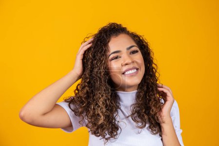 Photo for Beauty portrait of african american woman with afro hairstyle and glamour makeup. Brazilian woman. Mixed race. Curly hair. Hair style. Yellow background - Royalty Free Image