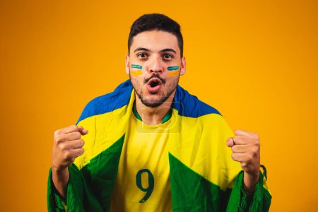 Photo for Brazilian fan cheering in the crowd on yellow background. - Royalty Free Image